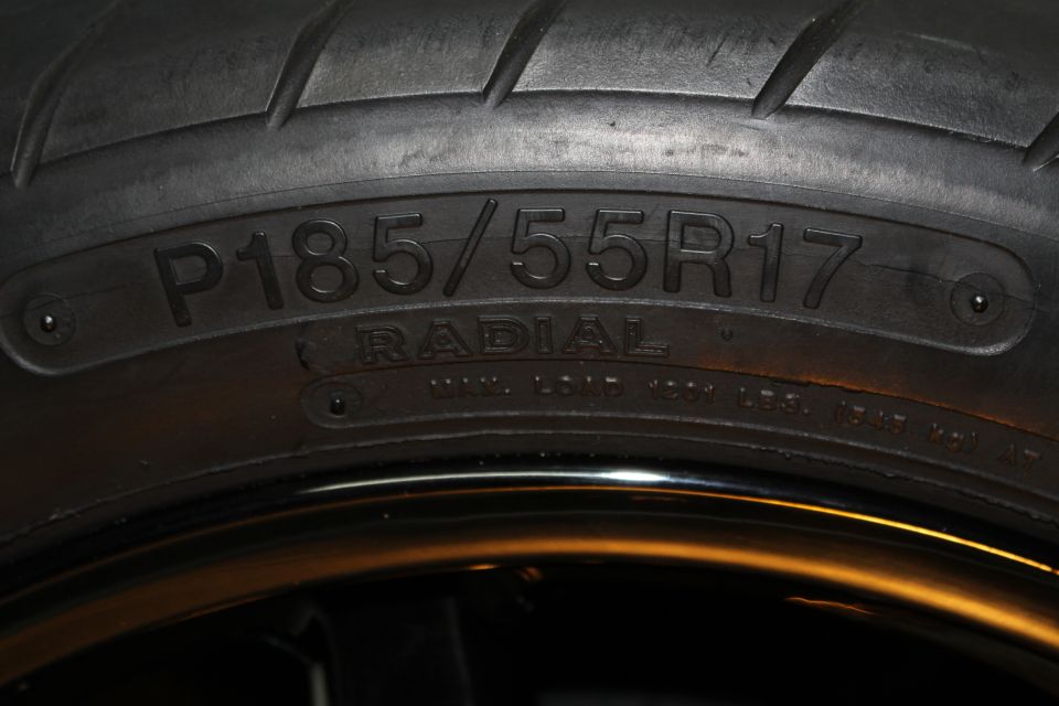 Tire sidewall close-up reading P185/55R17 RADIAL