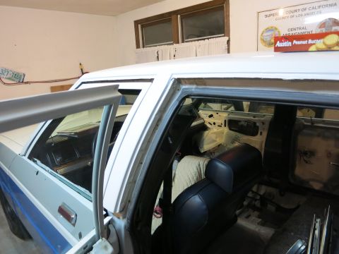 1991 Ford Crown Victoria LTD - The interior of a car is visible with the doors open, revealing a disassembled dashboard and seats, suggesting ongoing work.