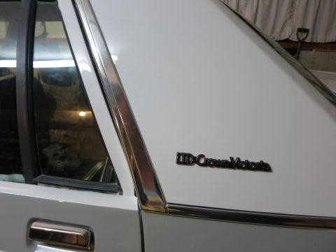 1991 Ford Crown Victoria LTD - Close-up of a white car's side panel showing the LTD Crown Victoria badging.