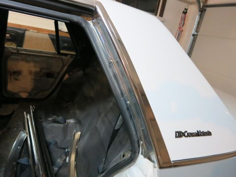 1991 Ford LTD Crown Victoria - The rear quarter panel and C-pillar of a white 1991 Ford Crown Victoria LTD are shown, with chrome trim and a "Crown Victoria" badge.