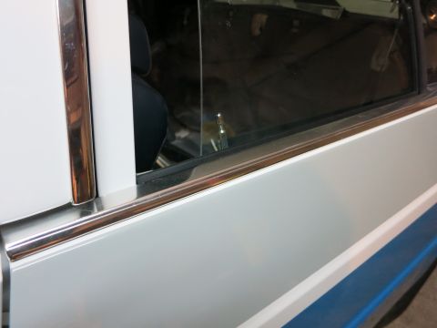 1991 Ford LTD Crown Victoria - Close-up of chrome trim detail on a white car door, with a glimpse of the interior visible through the window.