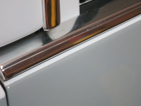 1991 Ford LTD Crown Victoria - Detail of chrome trim on a white vehicle door.