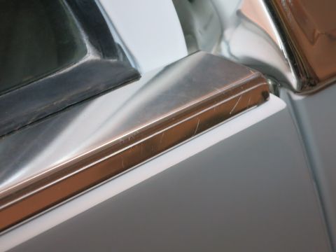 1991 Ford LTD Crown Victoria - A detailed view of a scratched chrome trim piece against a contrasting background.