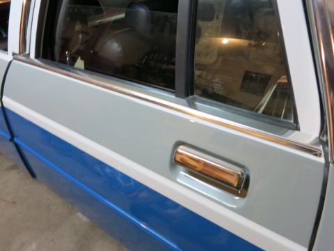 1991 Ford LTD Crown Victoria - Side view of a car door with a chrome handle and two-tone blue and grey paint.