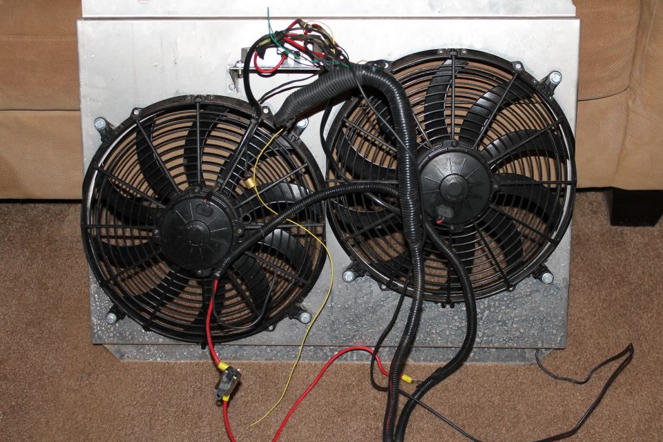 two electric fans wired together, mounted on a metal housing
