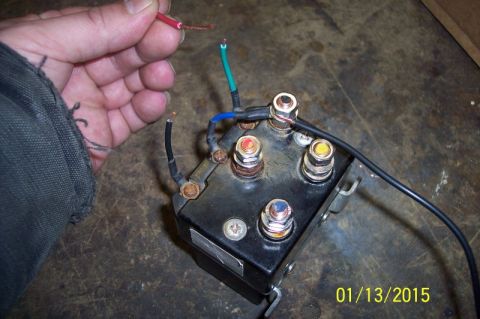 1973 Ford F-250 - A hand holds wires near a black winch controller with multiple terminals and attached wiring.