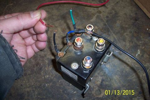 1973 Ford F-250 - Close-up of a winch controller relay with several wires attached, as a hand holds a red wire.