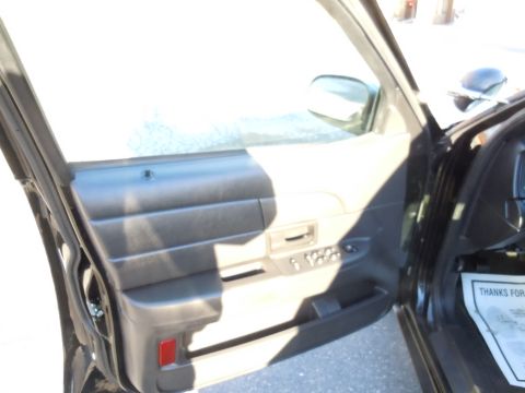 2001 Ford Crown Victoria - Interior view of a car door panel, showing the window controls and a red reflector.