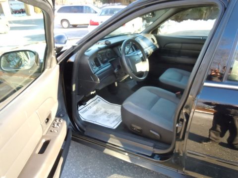 2001 Ford Crown Victoria - The interior of a 2001 Ford Crown Victoria is visible with the driver's side door open, revealing the dashboard and seating.