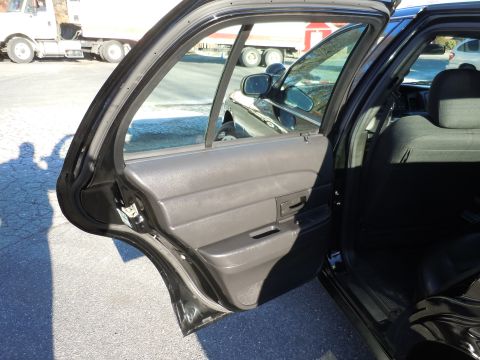 2001 Ford Crown Victoria - Interior view of a black 2001 Ford Crown Victoria, with the rear driver's side door ajar.
