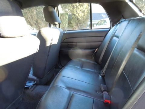 2001 Ford Crown Victoria - Interior view of the back seat area of a car, showing dark upholstery and seatbelts.