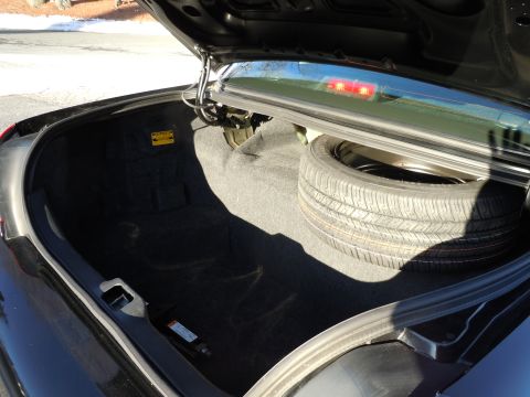 2001 Ford Crown Victoria - The trunk of a black 2001 Ford Crown Victoria contains a spare tire and jack.