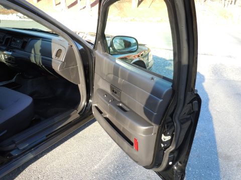 2001 Ford Crown Victoria - View of the interior of a 2001 Ford Crown Victoria, with the driver's door open, showing the dashboard and door panel.