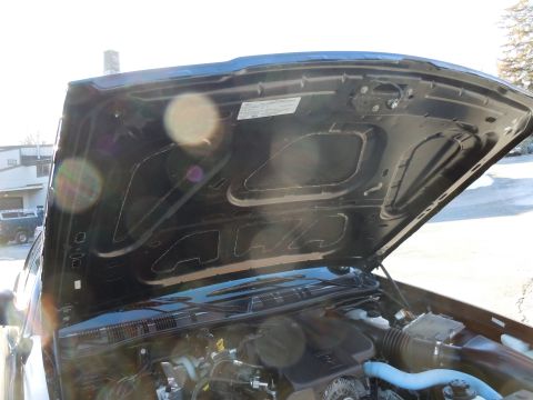 2001 Ford Crown Victoria - The engine bay of a vehicle is visible with the hood raised, revealing various components and insulation.