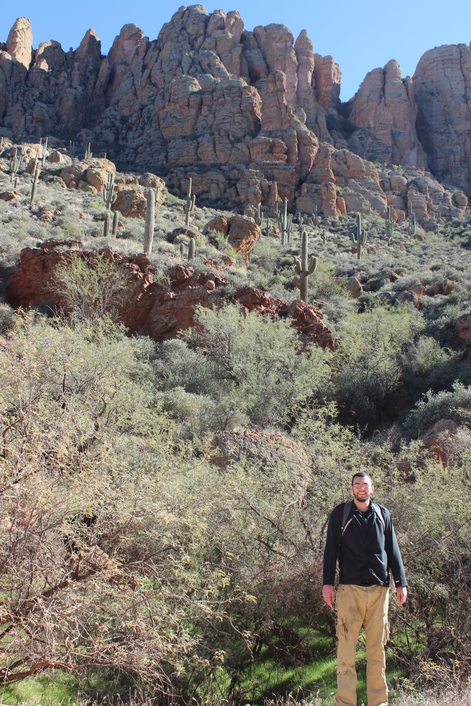 Man in desert with cacti and mountains