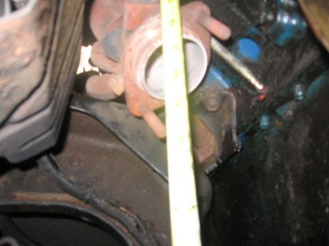 1988 Ford Bronco - A close-up view shows a yellow measuring tape positioned next to a metal exhaust component, possibly a manifold or downpipe, attached to a…