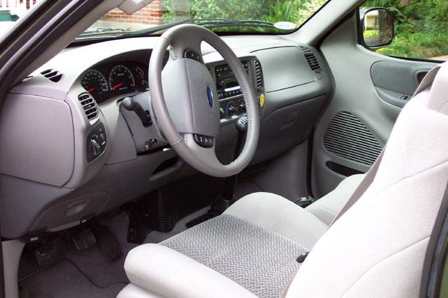 Interior of a 2003 Ford F-150, showing the dashboard, steering wheel, and seats