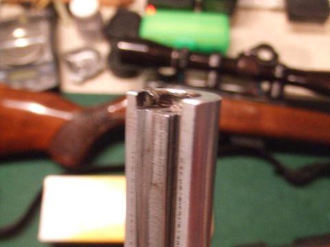 1996 Ford Bronco - A close-up, shallow depth-of-field shot focuses on the metallic bolt action of a rifle, with the wooden stock and scope visible in the blur…