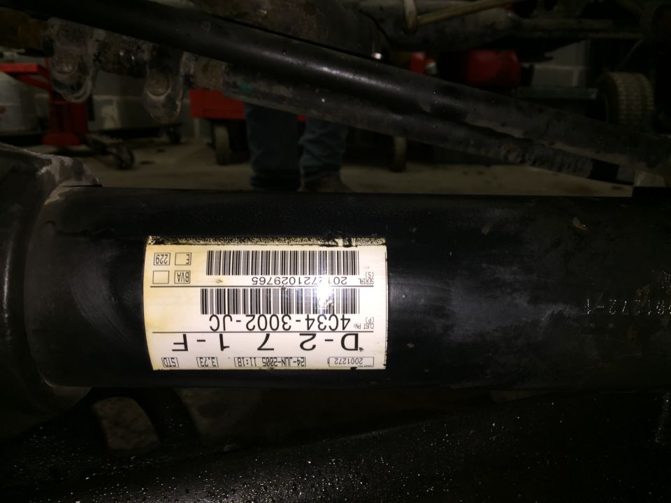 Black driveshaft with a label showing part number 4C34-3002-JC and date 24-JUN-2005.