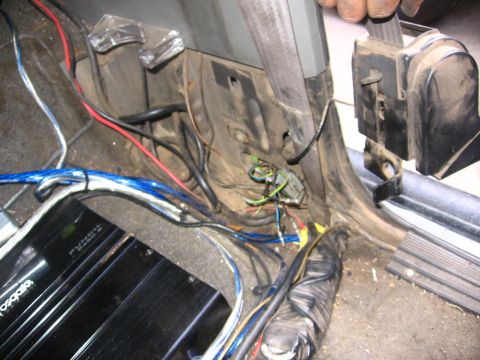 1988 Ford Bronco - Exposed wiring and an audio amplifier are visible in the passenger footwell of a car.