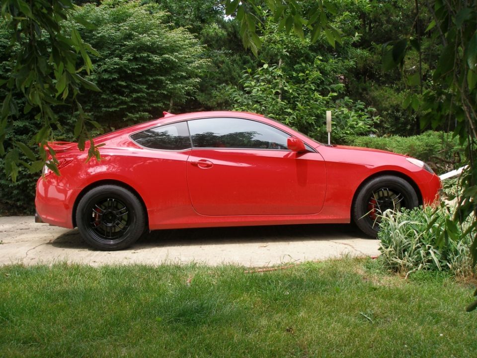 Red Hyundai Genesis coupe with black wheels parked outdoors.