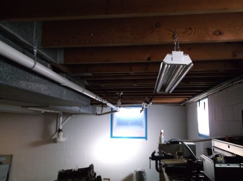 1995 Mercury Grand Marquis - Basement interior showing plumbing, lighting, and a window with blue tape around the frame.
