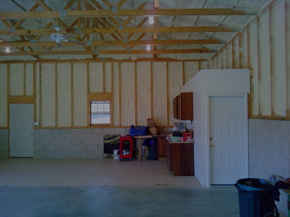 Garage interior with tools, cabinets, and doors