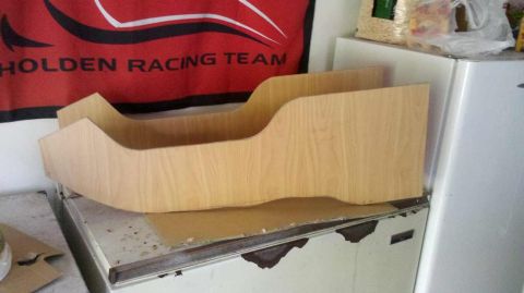 1982 Ford Bronco - A custom wooden console insert sits on a surface, with a Holden Racing Team banner displayed behind it.