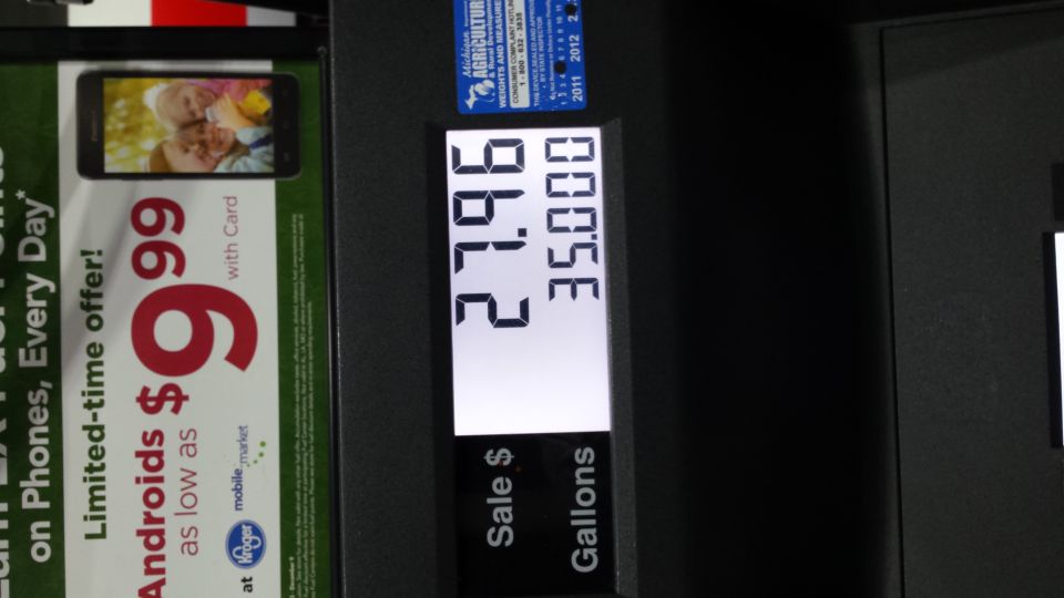 Gas pump display showing sale price and gallons, with a phone advertisement