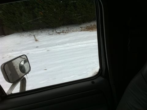 1988 Ford Bronco - Looking out the window of a vehicle on a snowy day, with a side mirror visible.