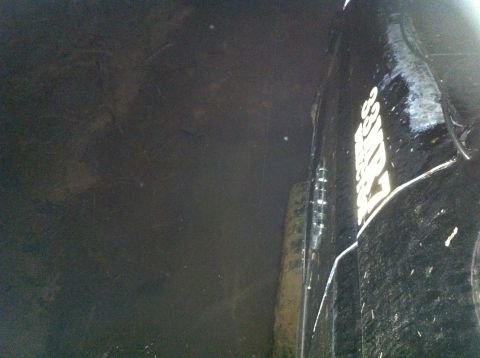 1988 Ford Bronco - A partial view of a vehicle's fender and tire, with a watermark from Supermotors.net.
