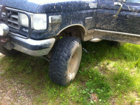 1988 Ford Bronco - Muddy 1988 Ford Bronco front quarter view, showing off its off-road tires and 4x4 badging.