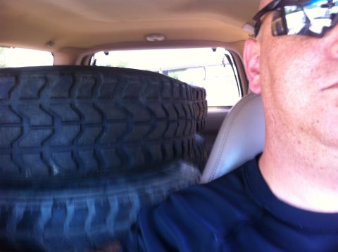 1988 Ford Bronco - Stacked tires are visible inside the cabin of a vehicle, obscuring the view.