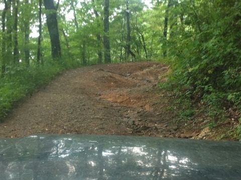 1988 Ford Bronco - Driving on a rough, unpaved path through a wooded area.