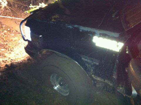 1988 Ford Bronco - This black Ford Bronco appears to be from the late 1980s, possibly a 1987 model, stuck in muddy terrain.