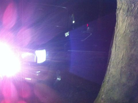 1988 Ford Bronco - A vehicle is seen at night with a bright light source illuminating its front. A tree is visible on the right side.