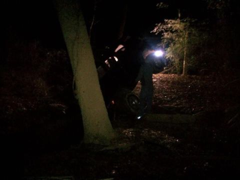 1988 Ford Bronco - A vehicle is stuck in a ditch at night, with a person using a flashlight.