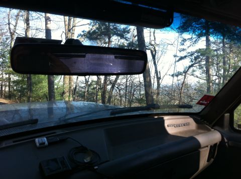 1988 Ford Bronco - View from inside a 1988 Ford Bronco shows the dashboard and a wooded landscape through the front window.