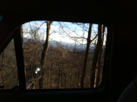 1988 Ford Bronco - Looking out the window at a winter forest scene with distant mountains.