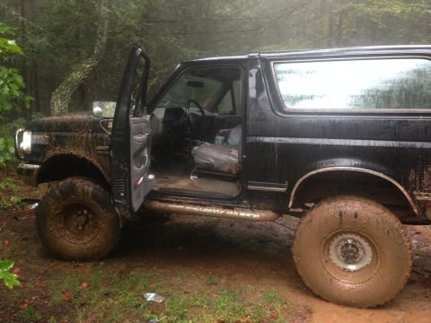1988 Ford Bronco - This black Ford Bronco appears to be from the late 1980s, possibly a 1987 model, and is covered in mud after off-roading.