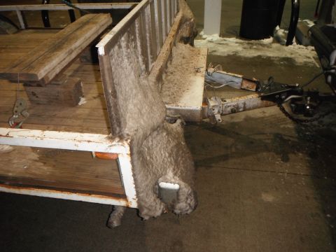 2000 Ford F-250 - Trailer hitch and frame with wooden planks and insulation. White metal, some rust visible.