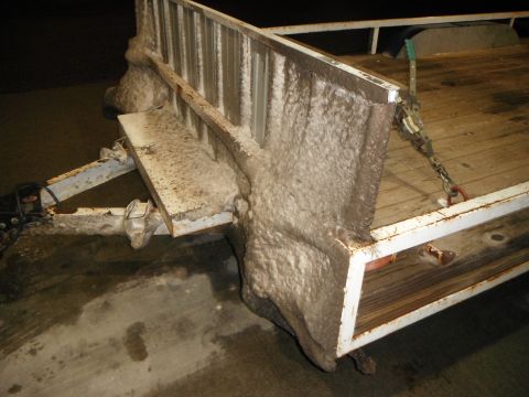 2000 Ford F-250 - Close-up view of a trailer hitch and bed, heavily coated in mud.