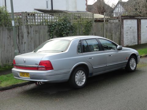 1999 Ford Fairlane - A silver sedan is parked on the side of a residential street, viewed from the rear quarter.