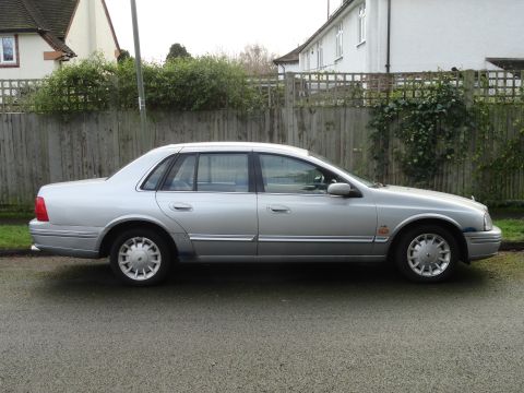 1999 Ford Fairlane - This silver sedan, identified by a 'Fairlane' badge on the fender, is seen from the side.