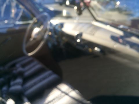 1968 Ford Mustang - Interior view of a 1968 Ford Mustang convertible, showing the dashboard and striped seats.