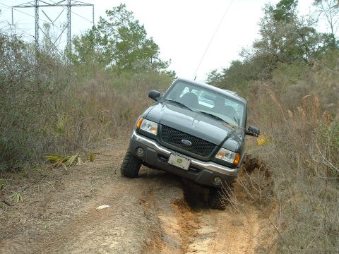 1995 Ford Bronco - A Ford Ranger navigates a challenging off-road trail with steep inclines and rough terrain.
