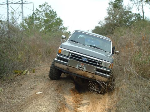 1995 Ford Bronco - This Ford truck appears to be from the late 1980s, not a 1995 model, as it navigates an off-road trail.
