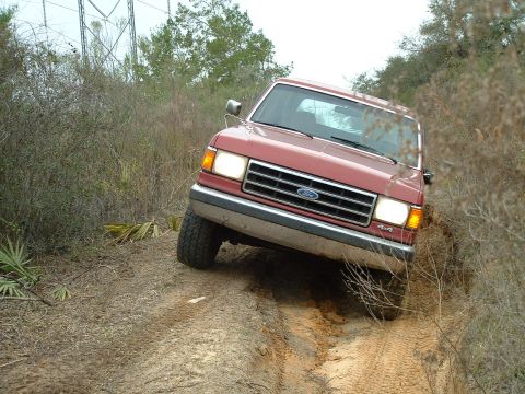 1995 Ford Bronco - This red 1995 Ford Bronco 4x4 navigates a challenging off-road trail.