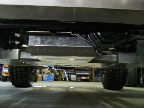 1992 Ford Bronco - The underside of a vehicle is shown, large off-road tires and a protective skid plate.