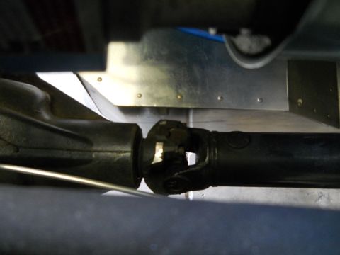 1992 Ford Bronco - Close-up view of a vehicle's driveshaft and U-joint, showing mechanical components.
